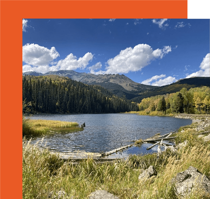 A lake with mountains in the background and clouds.