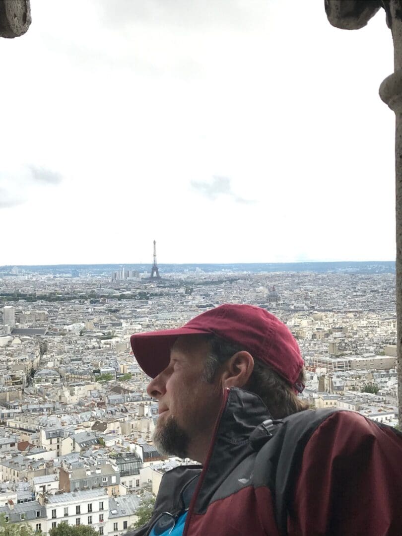 A man in red hat looking out over the city.