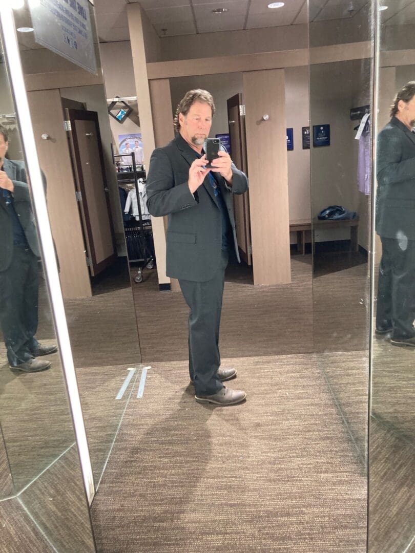 A man in suit and tie taking a picture of himself